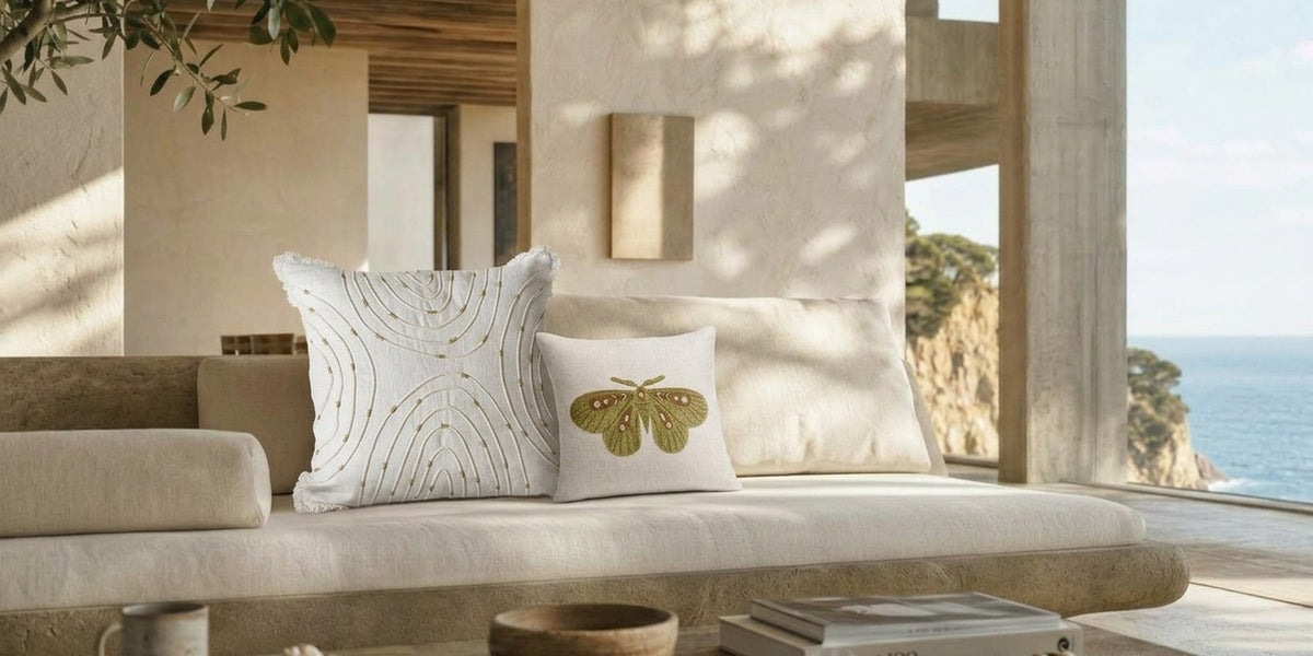 Dekokissen Schmetterling 3D Creme und Dekokissen Weiß Gold mit dekorativen Nähten zusammen in einem Zuhause am Meer