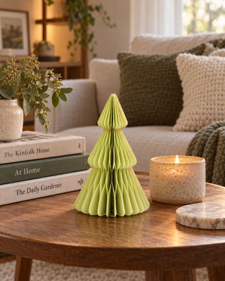 Papier-Tannenbaum stehend Pistazie auf einem Couchtisch neben Büchern